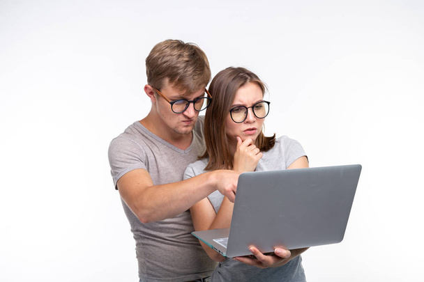 Nörtit, opiskelu, ihmisten käsite pari opiskelijaa katsovat nettikirjaa ja näyttävät pelokkailta valkoisella taustalla
 - Valokuva, kuva