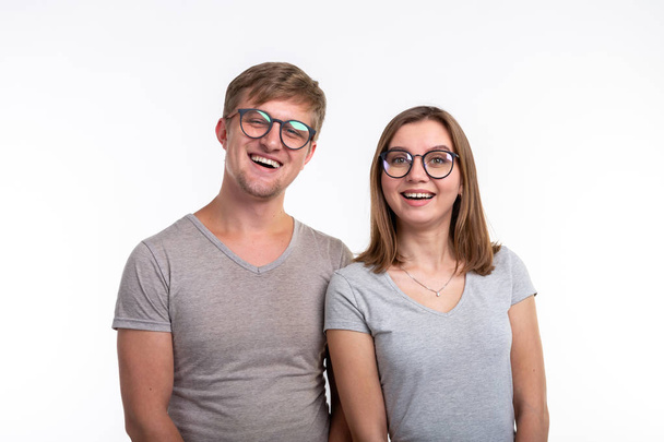 Ανθρώπους και εκπαίδευση έννοια - δύο νεαρός φοιτητής αστεία με προσεγμένες πρόσωπα πάνω από το λευκό φόντο - Φωτογραφία, εικόνα