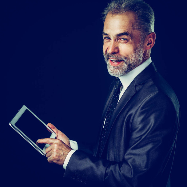 experienced businessman with digital tablet on black background. - Foto, immagini