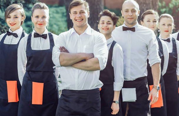 large group of waiters and waitresses who stand in the row behin - Photo, Image