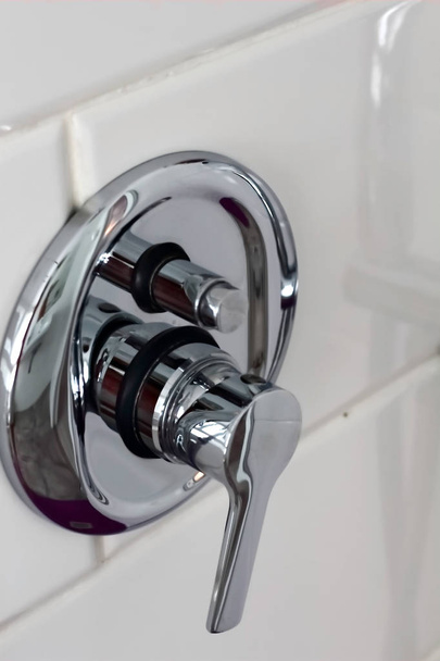 シルバーメタル光沢のあるシャワーのシャワーシャワーの水やりは、壁に白いタイルとホテルのホームバスルームで水スイッチすることができます。バスルームの豪華なインテリア  - 写真・画像
