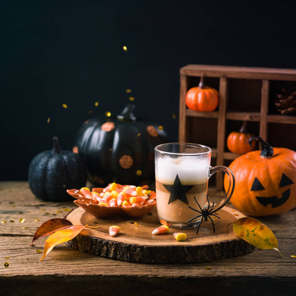 Halloween holiday concept with latte macchiato cup, candy corn   - Photo, image