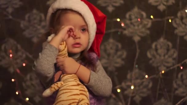 Christmas Girl Hugging Toy, Wearing A Santa Hat . - Filmagem, Vídeo