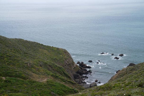 海の岩の入り江につながる丘の頂上からの眺め - 写真・画像