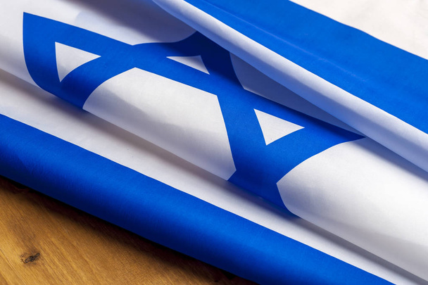Top view of flag of Israel lies on wooden table - Photo, image