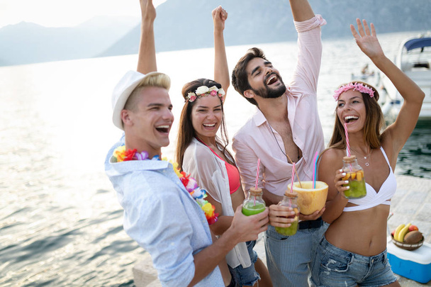 Summer party. Group of friends at beach drinking and having fun - Foto, Imagen