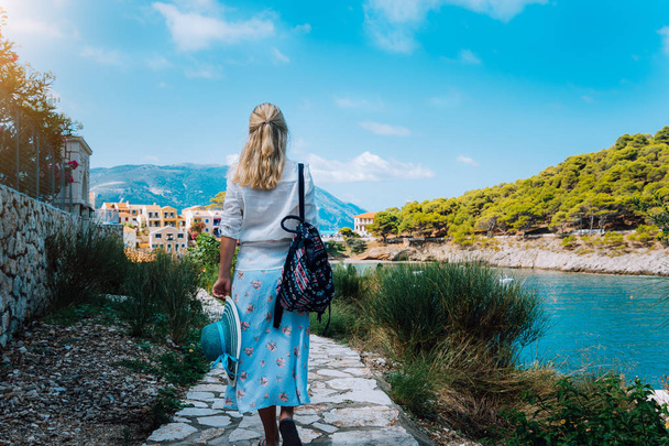 Donna di moda attraente in vacanza estiva sull'isola di Cefalonia. Bella donna abbronzata con cappello di paglia passeggiando lungo pittoresca città mediterranea, Grecia, Europa
 - Foto, immagini