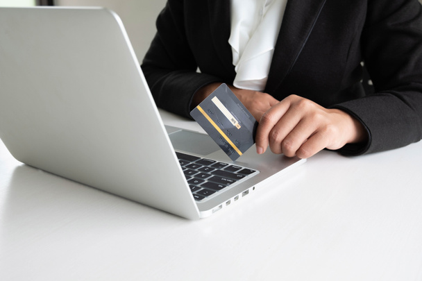 Mujer de negocios gasto del consumidor a través de tarjeta de crédito para compras en línea en su computadora portátil
 - Foto, Imagen