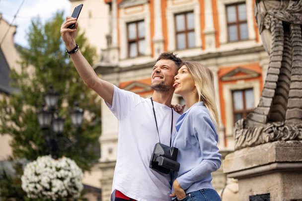 Travel selfie couple taking photo with phone at historical  city. Europe summer vacation young people smiling. Backpacking road trip. High Resolution.  - Foto, Bild
