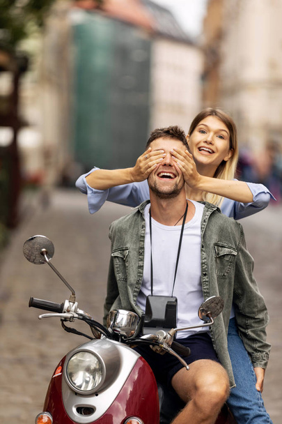 Happy couple of tourist travelers around city with motorbike scooter - Wander friends having fun on road trip in city - Travel concept with adult people on world tour - Warm filter - Photo, Image