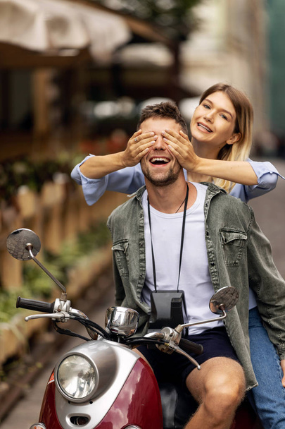 Happy couple of tourist travelers around city with motorbike scooter - Wander friends having fun on road trip in city - Travel concept with adult people on world tour - Warm filter - Фото, зображення