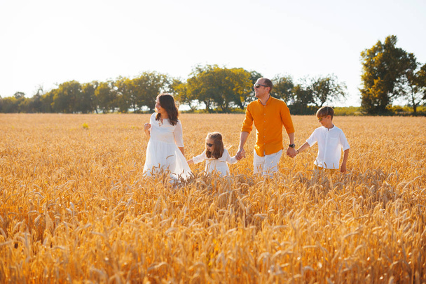 Foto von schöner Familie, die Spaß in einem Weizenfeld hat, und enjoyi - Foto, Bild