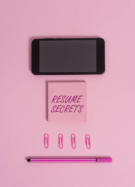 Text sign showing Resume Secrets. Conceptual photo Tips on making amazing curriculum vitae Standout Biography Colored blank sticky note clips smartphone pen trendy pastel background. - Photo, Image