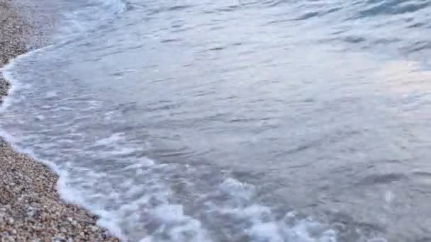 Pobřeží s malými oblázky a průzračné vodní vlny - Záběry, video