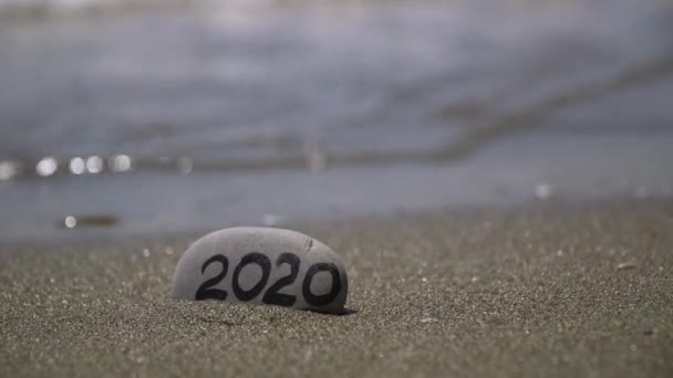 napis 2020 na kamieniu myte przez falę morską nowy rok pozdrowienia święta prezent - Materiał filmowy, wideo