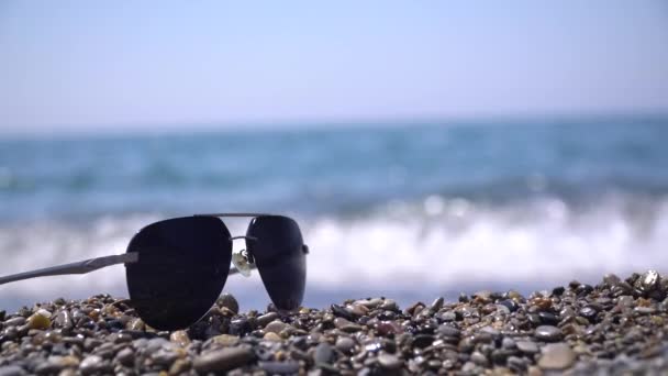Sonnenbrille am Strand gegen das Meer Sommertag - Filmmaterial, Video