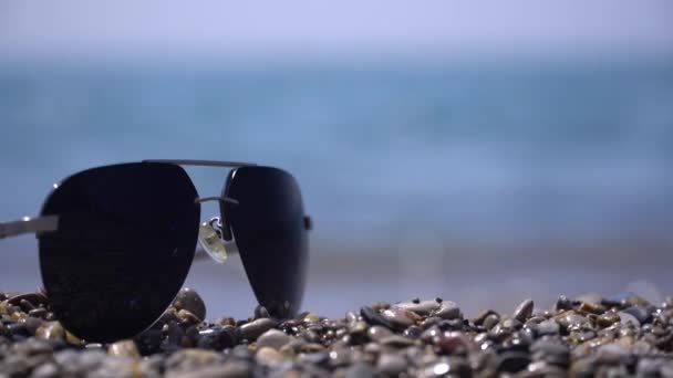 Plaża okulary przeciwsłoneczne vawesokulary na plaży przed morzem letni dzień - Materiał filmowy, wideo