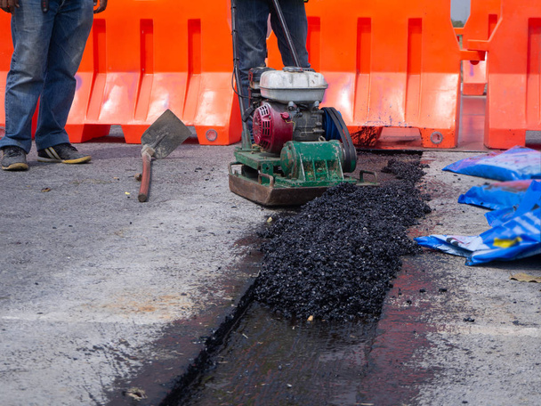 Trabalhador usar placa vibratória compactador compactação asfalto na estrada
 - Foto, Imagem