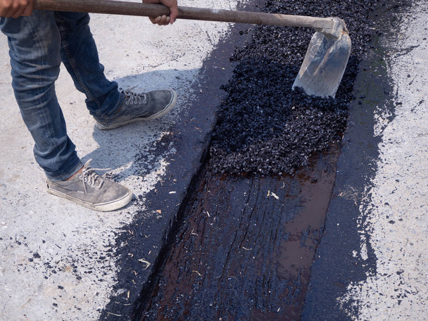 Travailleur utiliser plaque vibrante compacteur compactage de l'asphalte sur la route
 - Photo, image