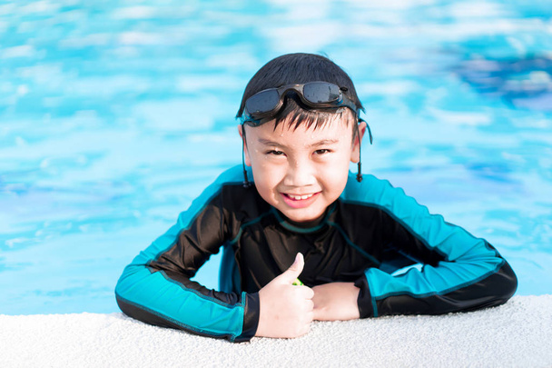glücklicher kleiner Junge schwimmt in einem Pool - Foto, Bild