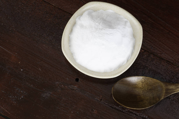 heap of white soda in white bowl plate and wooden spoon  - Photo, Image