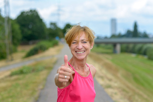Enthusiastic woman giving a thumbs up gesture - Photo, Image