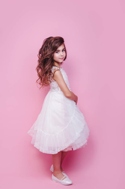 Full length of beautiful little girl in dress standing and posing on pink background - Foto, Bild