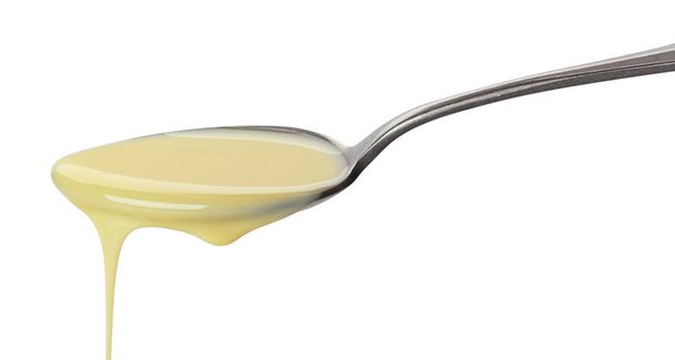 Pouring condensed milk isolated on white background - Photo, Image