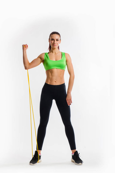 Fitness girl performs exercises with resistance band. Strength and motivation - Photo, image