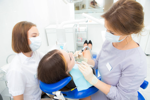 woman dentist treats a tooth to a woman - Fotoğraf, Görsel