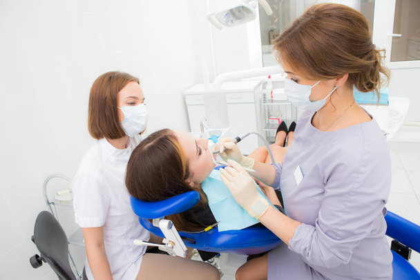 女性の歯科医は女性に歯を扱う - 写真・画像