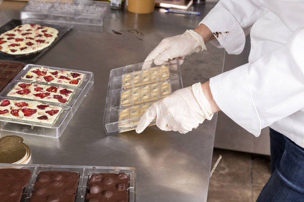 Removing a chocolate bar from a plastic mold. - Photo, image