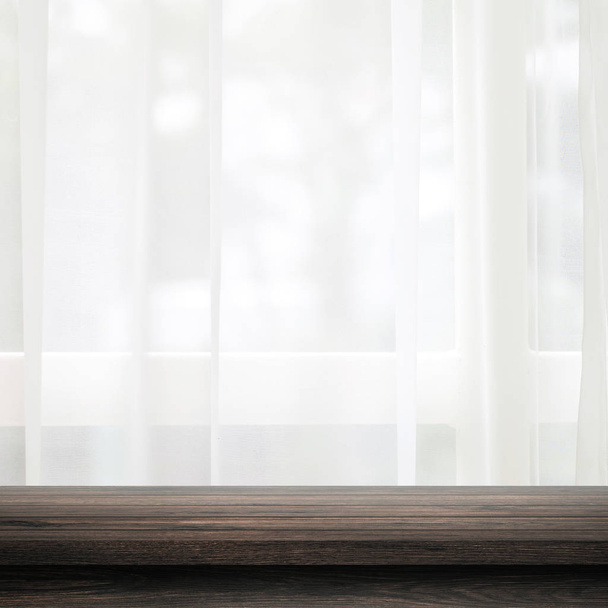 Vacío de mesa de madera en la cortina y el fondo de la ventana con desenfoque de la naturaleza concepto de la mañana ambiente. Mesa de madera negra y espacio para colocar su producto o diseño
. - Foto, imagen