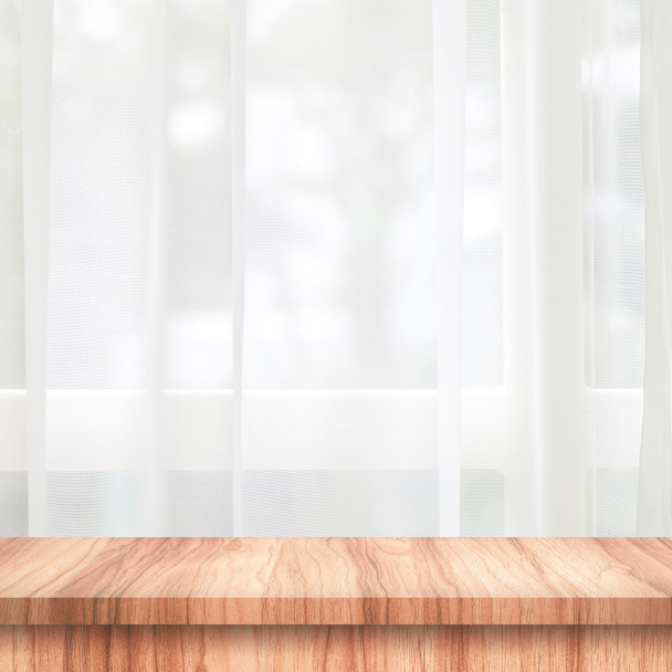 Leeg van houten tafelblad op gordijn en raam achtergrond met vervagen van natuur milieu ochtend concept. Houten tafel en ruimte voor het plaatsen van uw product of ontwerp. - Foto, afbeelding