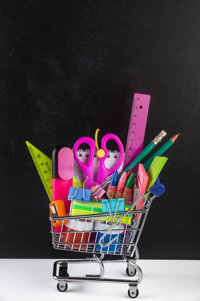 Shopping cart stocked with school supplies and a blackboard - Фото, зображення