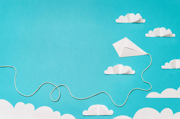 Paper cut clouds and origami kite composition. Creative concept for banner/landing/background designs. - Foto, afbeelding