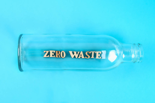 Zero waste concept. Empty glass bottle for zero waste shopping and storage on blue background - Photo, image