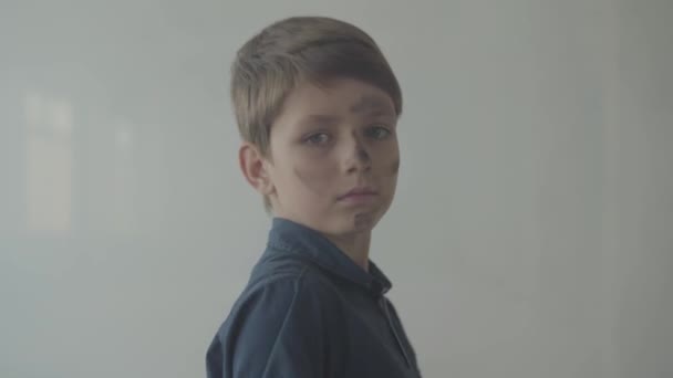 Little boy with dirty face looking at the camera and walking in the smoke cloud. Child disappearing in smoke cloud. Concept of fire, flammability, non-compliance with safety rules. - Záběry, video