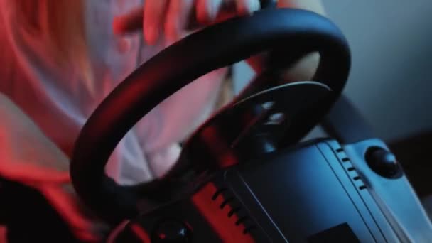 Крупним планом руки молодого геймера за кермом гоночного симулятора. Молодий геймер насолоджується автомобільною гоночною відеогрою з колесом. Комп'ютерне моделювання
. - Кадри, відео