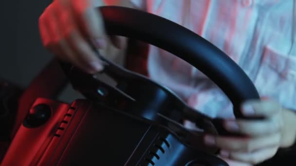 Close-up of the hands of a young gamer behind the steering wheel of a racing simulator. Young gamer enjoying car racing video game with a wheel. Computer simulation. - Footage, Video