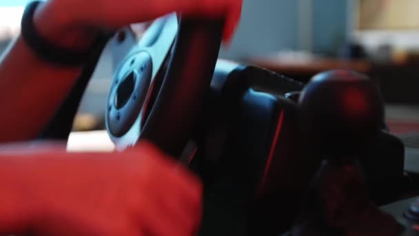 Крупним планом руки молодого геймера за кермом гоночного симулятора. Молодий геймер насолоджується автомобільною гоночною відеогрою з колесом. Комп'ютерне моделювання
. - Кадри, відео