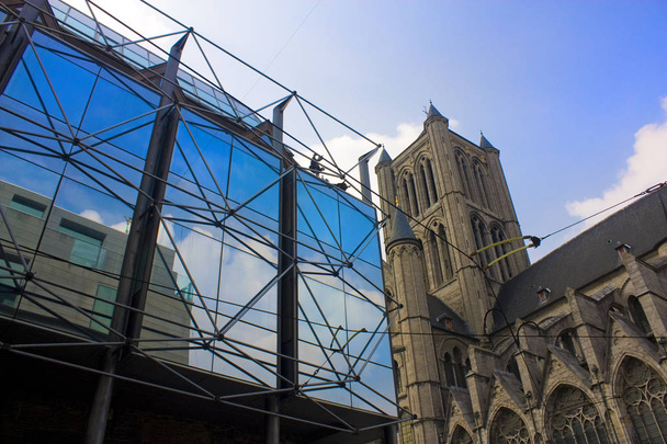 GHENT, BÉLGICA - 3 de mayo de 2019: Iglesia de San Nicolás y edificio de vidrio moderno en Gante, Bélgica
 - Foto, Imagen