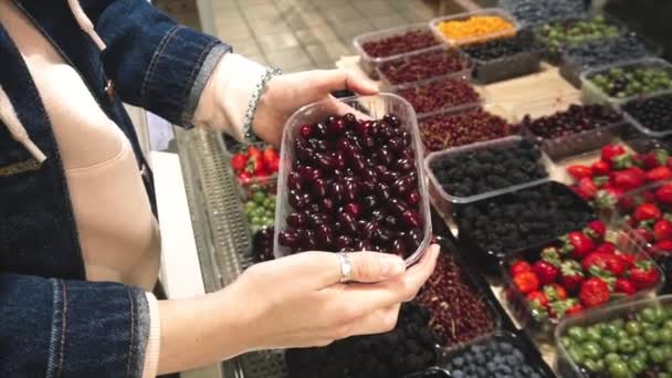 Vegetáriánus nő választja karneol cseresznye a szupermarketben.  - Felvétel, videó
