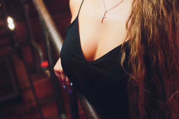 Decollete, female breast. Neckline black dress and fur collar. - Фото, зображення