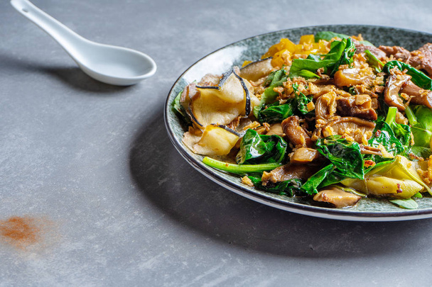Close up pan-asian thai salad bowl. Flat lay food on grey stone background. Warm salad with veal, spinach, mushrooms and spices. Copy space. Banner, menu, poster photo - Foto, immagini