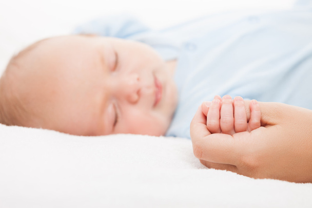 Cute sleeping newborn baby child holding mother hand - Foto, Imagem
