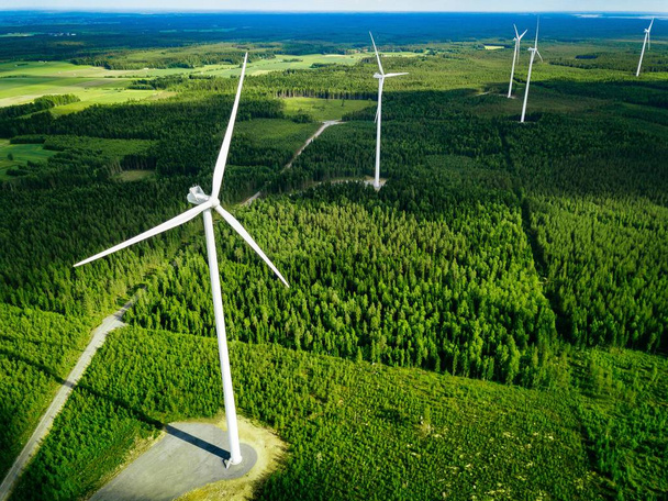 Letecký pohled na větrné mlýny v letním lese ve Finsku. Větrné turbíny pro elektrickou energii s čistou a obnovitelnou energií  - Fotografie, Obrázek