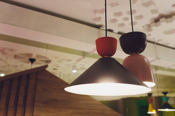 moderne Kronleuchter mit LED-Lampen hängen an der Decke im Inneren des Raumes im Haus, Design von zu Hause, warmes Licht von Schatten. - Foto, Bild