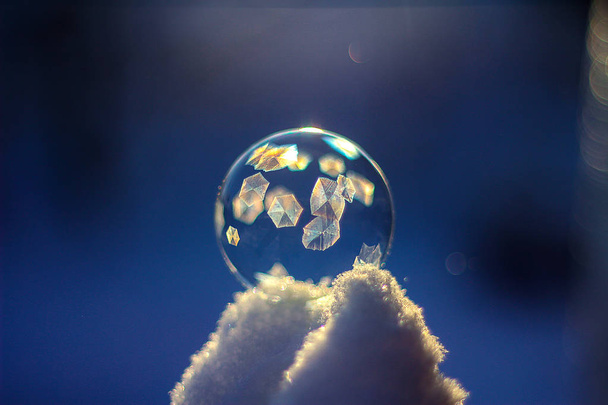 Gün batımında kar üzerinde Dondurulmuş sabun kabarcık topu, kristal oluşumu - Fotoğraf, Görsel