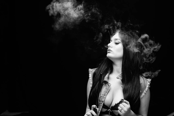 Girl vaping. Hookah bar. Electronic cigarette. Fashion girl vaping. Relaxing with hookah. White cloud of smoke. Vaping is sexy. Nicotine addiction. Attractive busty brunette smoking vaping device - Fotografie, Obrázek